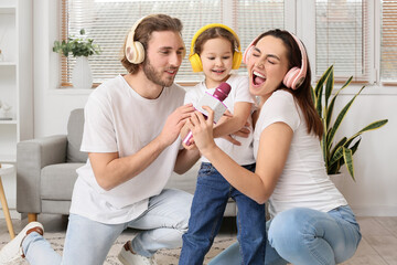 Happy family with headphones and microphone singing song at home