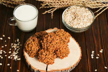 The oatmeal cookies, healthy breakfast cereal oat crackers and milk. Crispy anzac biscuit cookie with oat flakes on rustic table