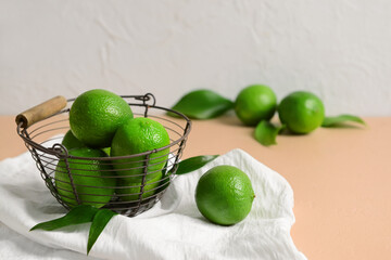 Basket with ripe limes on table