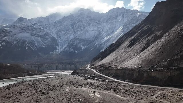 Aerial View Of New Section Of KKH Road With Snow Covered Mountain In background. Zoom in