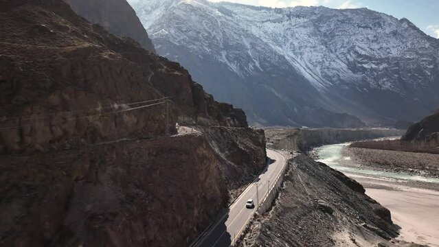 Aerial View Tracking White Car Driving Along New KKH Karakoram Highway Road In Pakistan