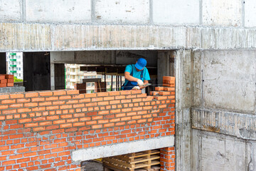 Bricklayer lays a partition during the construction of a frame monolithic structure