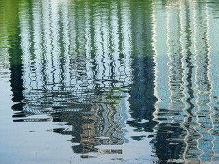 abstract water reflection of skyscraper in the river with wave stream