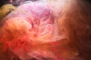 Fototapeta na wymiar Orange pink smoke on black ink background, colorful fog, abstract swirling touch ocean sea, acrylic paint pigment underwater