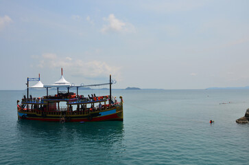 Naklejka na ściany i meble Ship cruise or boat tour stop for send receive thai people and foreign travelers travel visit rest relax and play swimming water in sea ocean in Gulf of Thailand at Koh Chang island in Trat, Thailand