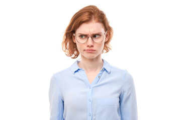 Smart redhead girl in business shirt and glasses grimacing and biting lips thinks doubts, makes decision isolated on white studio background