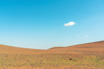 Lonely cloud over mountain meadow