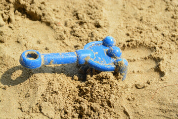 Fototapeta na wymiar Blue rake kids toy was placed on sand at the beach.
