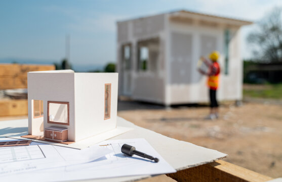 Engineering and architect woman working with house model at the construction property site.