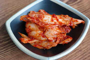 Cabbage kimchi is served on a plate.
