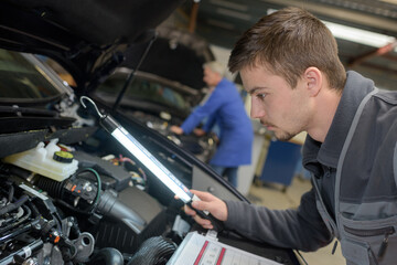 student with instructor repairing a car during apprenticeship