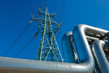 pipeline and power line pylon, in the photo, pipeline close-up, power line pylon and blue sky in...