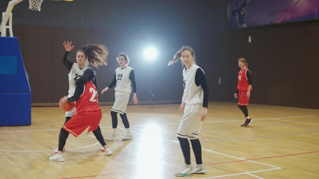 Slow motion, basketball championship, female player successfully scores the ball in the basket, the confrontation of two females team of basketball players, woman power, training game.
