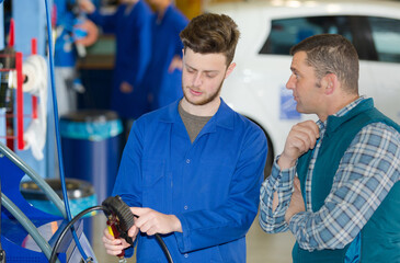 Fototapeta premium two mechanics working on a car