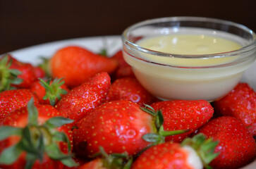 Ripe juicy strawberries with condensed milk