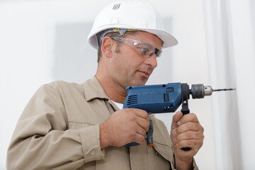 man drilling the wall with drill perforator