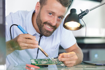 man soldering a circuit board