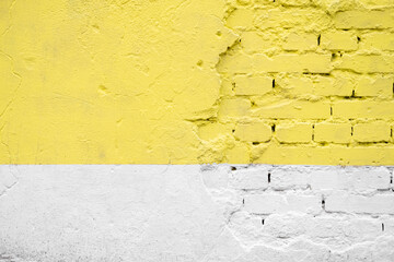 Yellow and white brick wall texture background. Beautiful street art detail on house exterior. Brush strokes. Old, painted, weathered and cracked bricks with concrete and stucco. Close up, copy space