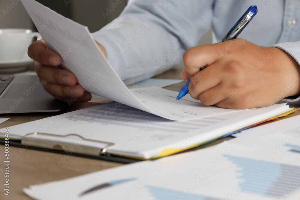 Poster businessman working reading documents signing contract on paper business document working on laptop 