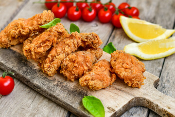 
 Crispy  deep Fried   Chicken strips and wedges potato. Breaded  with cornflakes chicken  Breast Fillets  with chilly peppers and fresh   basil on wooden rustic background