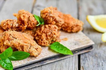 
 Crispy  deep fried   chicken strips and wedges potato. Breaded  with cornflakes chicken  breast fillets  with chilly peppers and fresh   basil on wooden rustic background