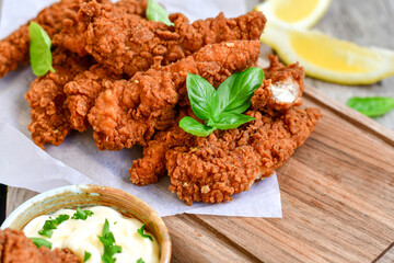
 Crispy  deep Fried   Chicken strips and wedges potato. Breaded  with cornflakes chicken  Breast Fillets  with chilly peppers and fresh   basil on wooden rustic background