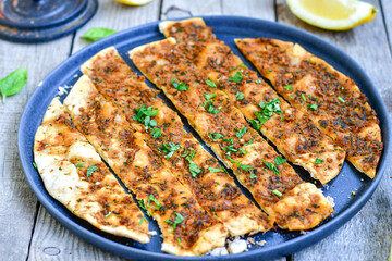  Traditional Turkish cuisine. Baked Pide dish with minced  beef, tomatoes and  herbs on  wooden background.  Turkish pizza pide