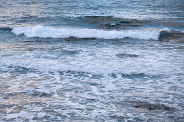 Pastel-gray sea. texture of a raging ocean, full frame with space for text. The concept of weather, vacation, travel. The purest clear sea water, big waves close-up. Calm natural light gray background