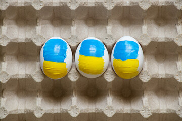 White chicken egg with a painted flag of Ukraine on the table at home, culture and holidays in the...