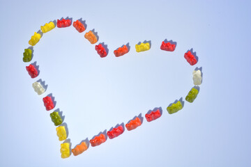 Jelly bears candy on a white background.Gummy bear heart.candy heart.Jelly lowcalorie sweet. Children's dessert.Jelly multicolored bears assorted.Sweet pattern in yellow and red colors.