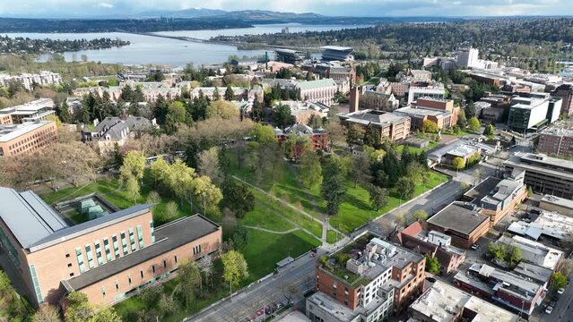 Cinematic drone trucking shot of the University of Washington campus, University District with surrounding commercial and residential area, dormitories and classroom buildings in Seattle Washington