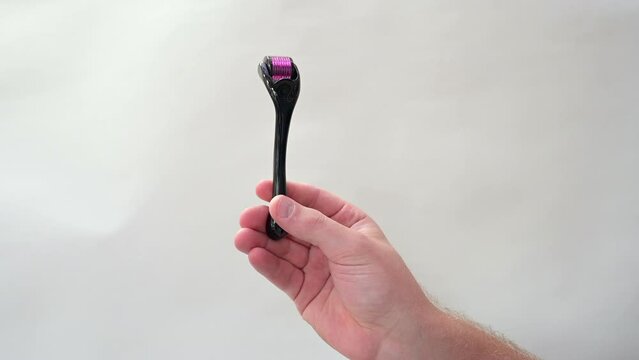 Lockdown Shot Of Man Showing Derma Roller In Front Of White Wall At Home - Negev, Israel