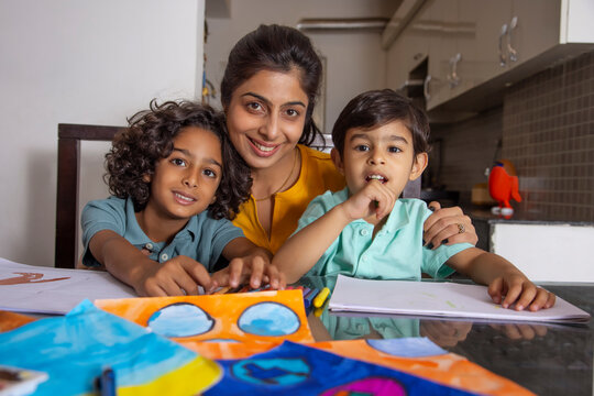 Mother with her children looking at camera during painting 