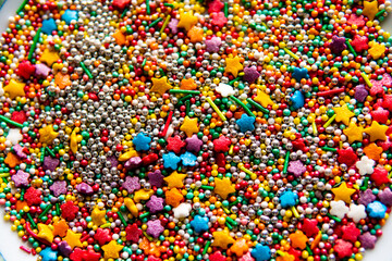 Fototapeta na wymiar Colorful sprinkles on white background, top view. Confectionery decor