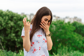 Woman applies nasal spray. Young woman using nose spray for her pollen and grass allergies (Allergy...