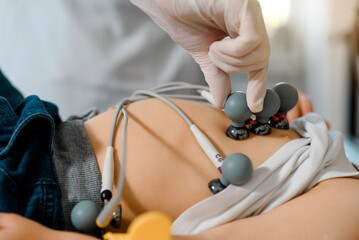 ECG electrodes on child chest for pediatric electrocardiogram to diagnose kids cardiovascular diseases.