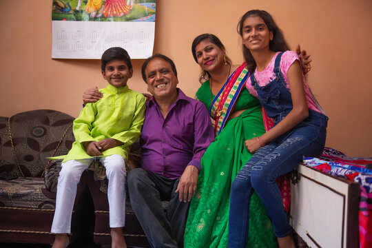 Portrait Of Cheerful Family Sitting Together At Home