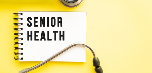 Text SENIOR HEALTH on notebook with stethoscope on yellow background.