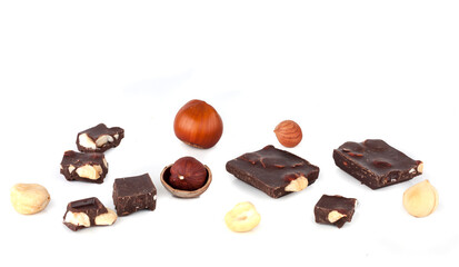 Naklejka na ściany i meble Pieces of chocolate and hazelnuts isolated on a white background