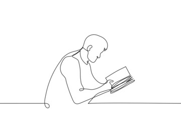 man reading a book sitting at the table - one line drawing vector. concept of reading paper (analogue) book, visiting the library