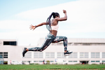Young African-American athlete sprinter jumping