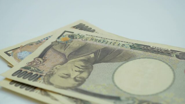 Counting japan money banknotes on white.