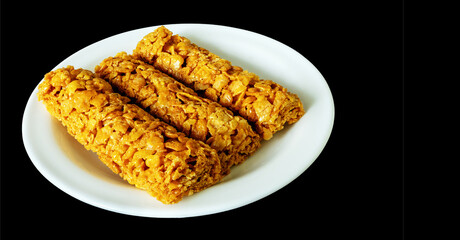breakfast cereal bars with vitamins on a plate on a black background