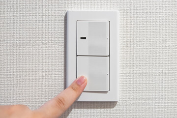 Finger turning light switch off to save power