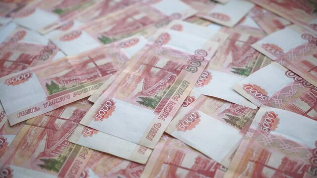 Russian banknotes with a face value of 5000 rubles fall on the table. Background of Russian money. Counts money.