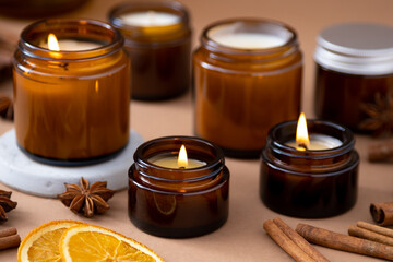 A set of different aroma candles in brown glass jars. Scented handmade candle. Soy candles are burning in a jar. Aromatherapy and relax in spa and home.
