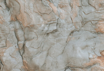 Large rock in grey red color palette. Natural stone texture, big cliff close up. Abstract organic background.