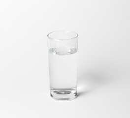 A clean transparent glass of water on a white background. Side and top view with shadow
