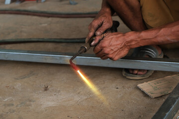 A male welder is making a steel frame construction