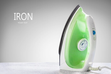 Steaming iron on ironing board near window with copy space. The housework and housekeeping concept.